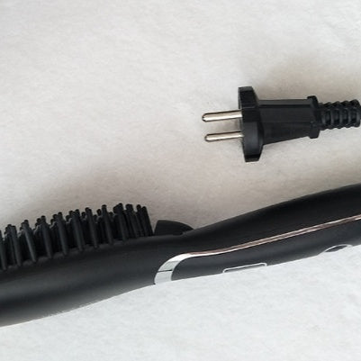 Hair straightener with plug on a white surface