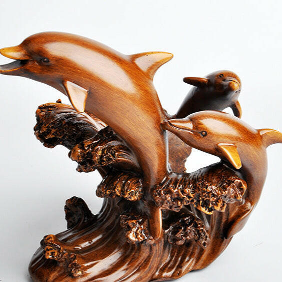 Wooden sculpture of three dolphins on a wave