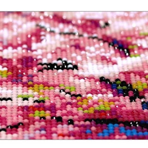 Close-up of a beaded pattern with pink, black, and multicolor beads.