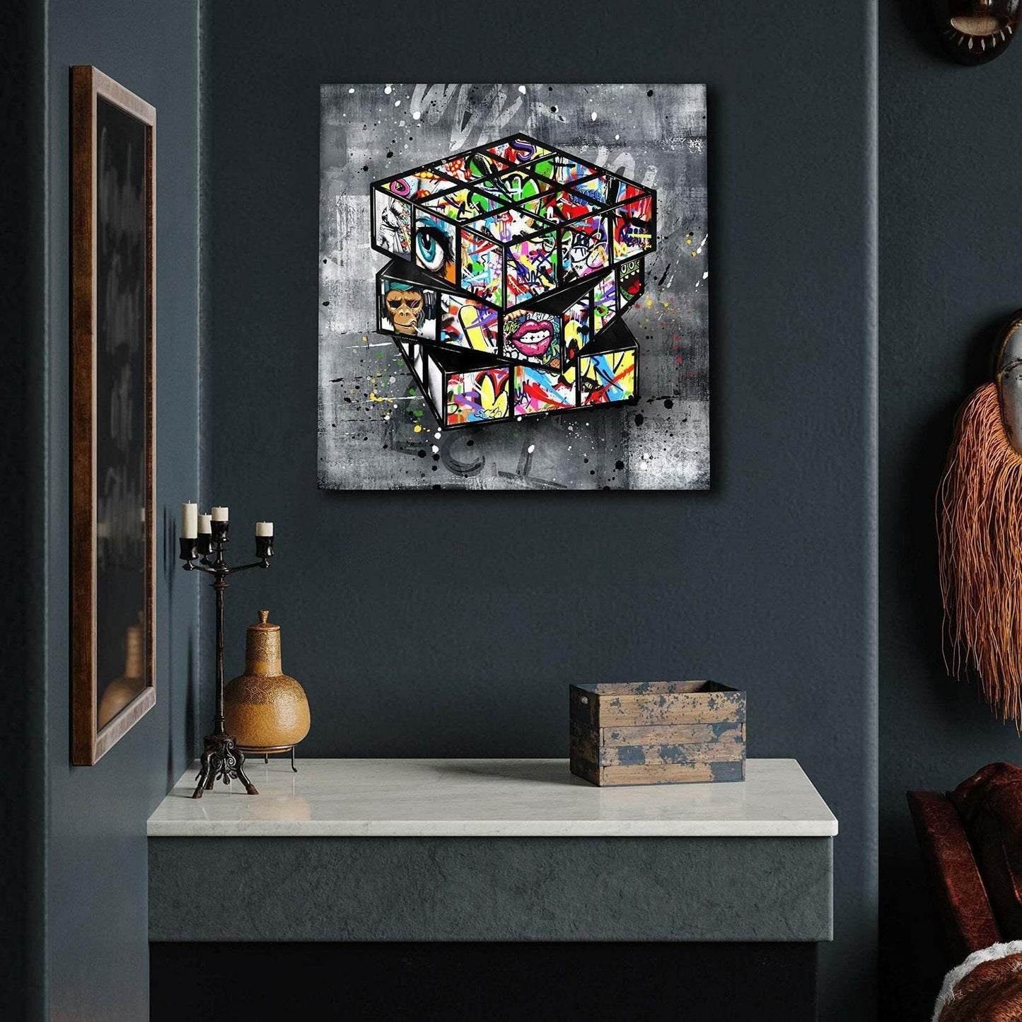 Abstract art of a Rubik's Cube on a dark wall with decorative items below.