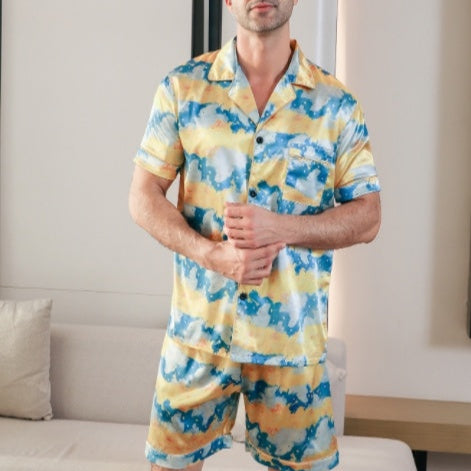 Man wearing a yellow and blue patterned pajama set in a living room.