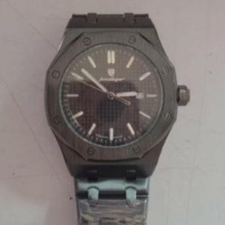 Black wristwatch with a silver band on a light gray background