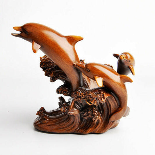 Wooden sculpture of a dolphin leaping over a wave on a white background