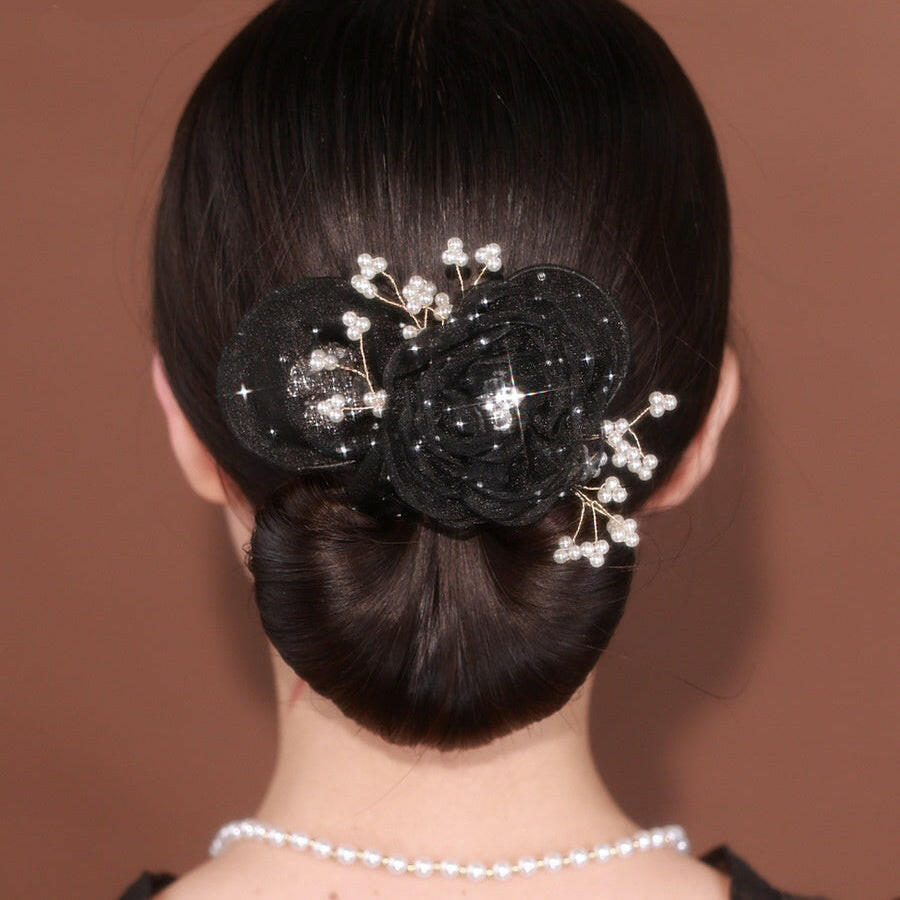 Black floral hair accessory with pearls on a brown background