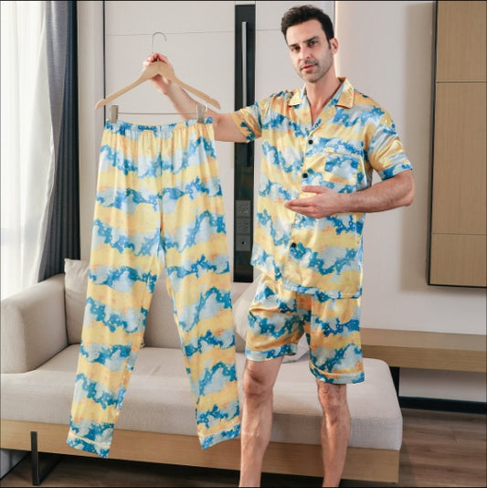 Man holding a matching yellow and blue pajama set in a living room.