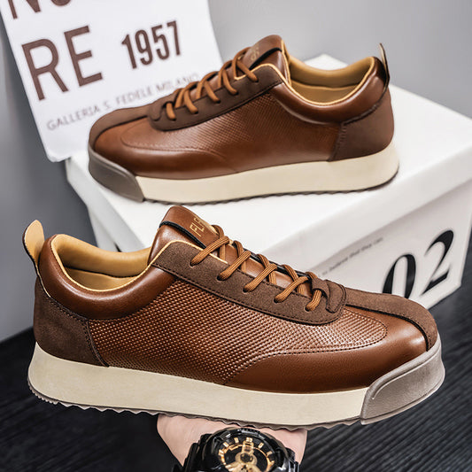 Brown leather sneakers on a dark surface with a blurred background