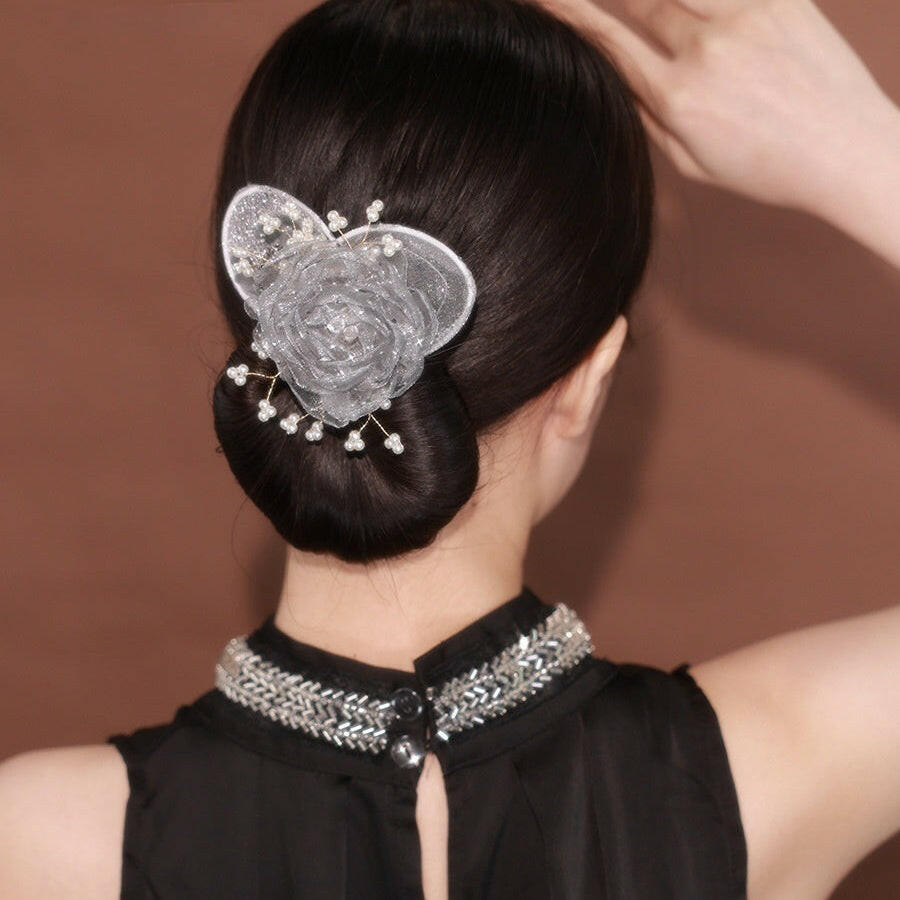Woman with a decorative hairpin in her bun against a brown background